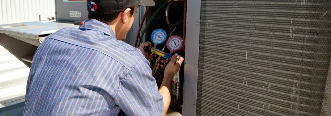 HVAC technician servicing a condenser unit in Powder Springs