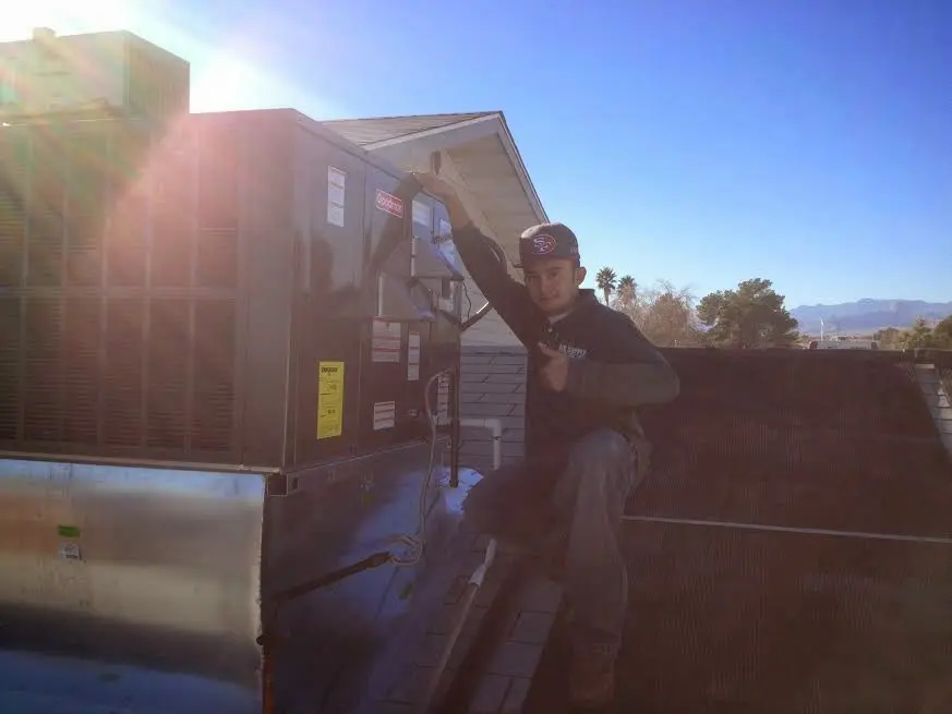 HVAC technician performing Air Duct Repair on a rooftop unit in Powder Springs